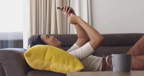 Person Relaxing on Couch While Enjoying Smartphone