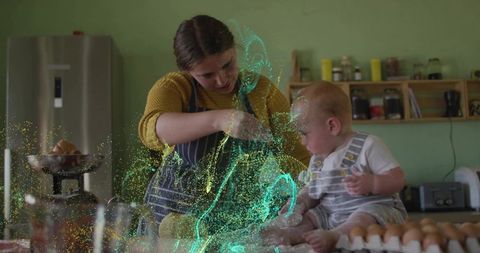 Baking mother with baby on counter creating glowing flour swirl and joyful kitchen mess