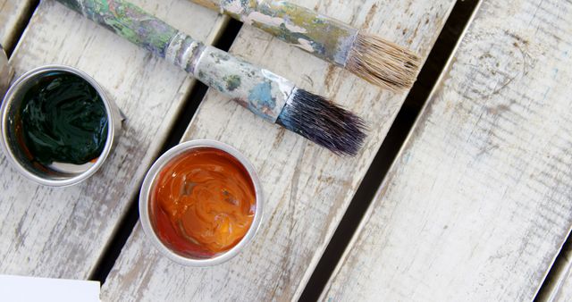 Overhead view of various watercolor with paintbrush on wooden table