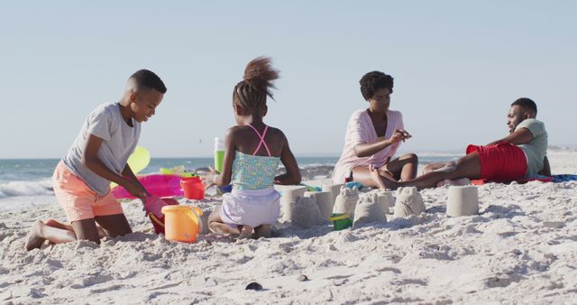 Family Enjoying Beach Day with Sand Castles and Relaxation - Download Free Stock Images Pikwizard.com