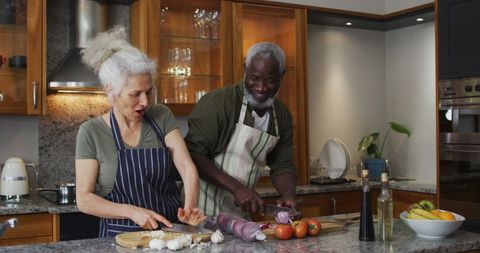 Senior Couple Joyfully Preparing a Meal Together in Kitchen