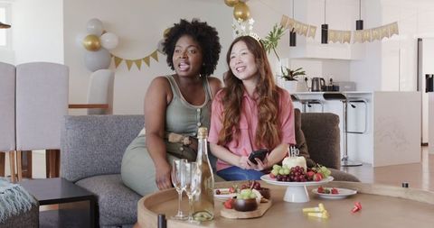 Lesbian couple smiling at intimate birthday celebration at home