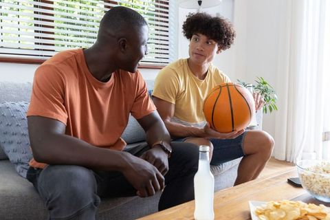 Diverse Friends Relaxing at Home with Basketball and Snacks
