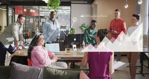 Diverse team collaborating around table with data visualization overlay in modern office