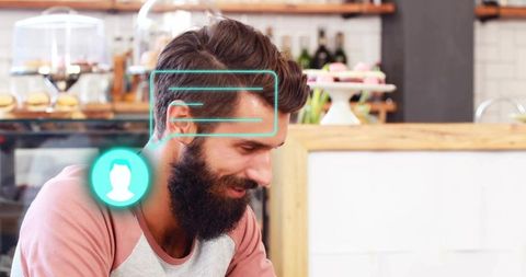 Bearded man in cozy cafe leaning forward and viewing augmented reality ui overlay