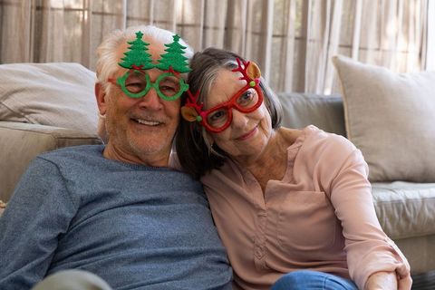 Senior Couple Smiling with Festive Christmas Glasses at Home