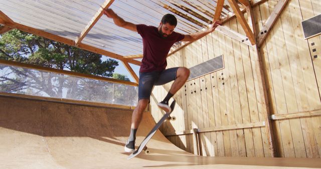 Image of middle eastern male skateboarder training in skate park. Skateboarding, sport, active lifestyle and hobby concept.