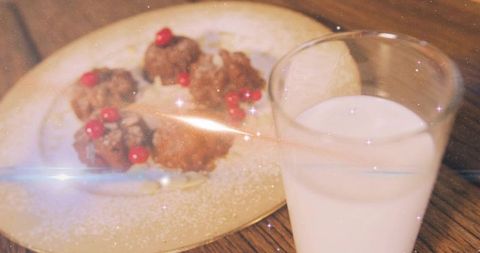 Serving vintage holiday fritters with glass of milk on rustic wooden table