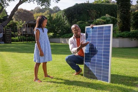 Father Introducing Solar Energy to Daughter in Garden