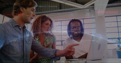 Diverse Team Analyzing Data Streams on Laptop in Office