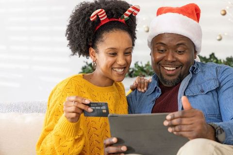 African american couple shopping online for christmas with tablet and credit card