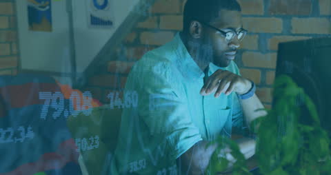African American Man Analyzing Stock Market Data on Computer