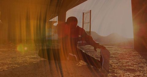 Male Athlete Stretching Under Overpass at Sunset with Dramatic Lens Flare Silhouette Urban