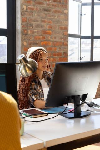 Modern Urban Office with Focused Diverse Coworker Using Computer