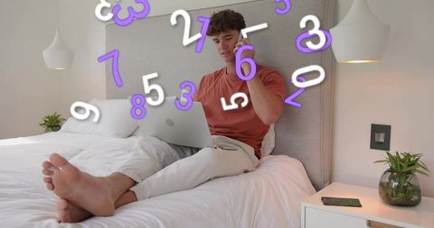 Young man working remotely on laptop while talking on phone with floating numbers overlay