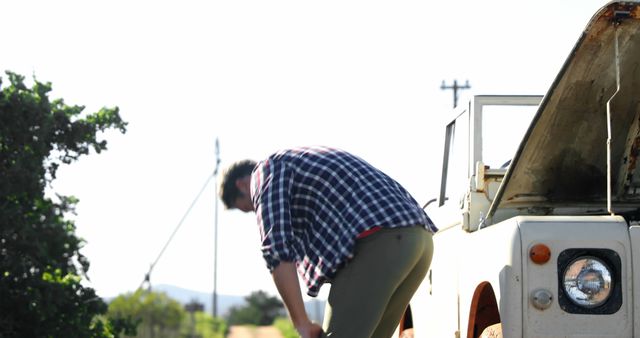 Person Repairing Broken-Down Vehicle in Countryside - Download Free Stock Images Pikwizard.com