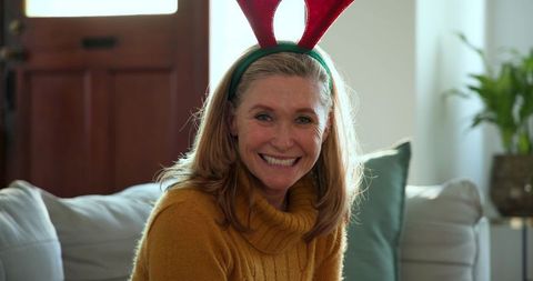 Mature woman with festive antler headband wanting seasonal moment
