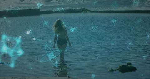 Woman wading in bay with futuristic holographic overlay