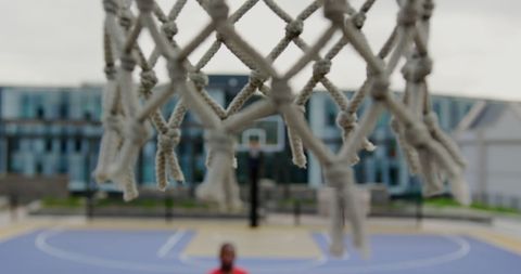Close-Up of Basketball Hoop Net with Blurred Court Background