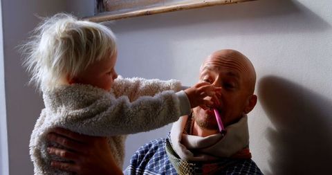 Playful Interaction Between Father and Daughter Indoors
