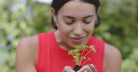 Woman Enjoying Fragrant Seedling in Lush Garden Setting