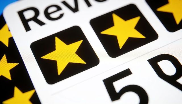 Close-up digital rating interface displaying yellow stars on black tiles with partial 5