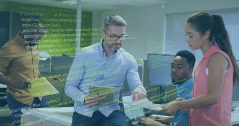 Tech lead reviewing code with team collaborating at modern office workstation