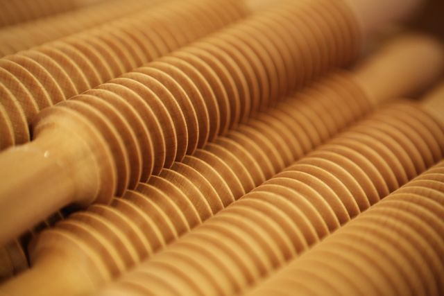 Close-up view of multiple wooden ravioli rolling pins, showcasing their grooved patterns. This image is ideal for use in cooking blogs, culinary websites, or advertisements that focus on traditional Italian cooking tools and recipes.