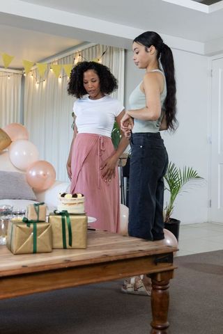 Friends Preparing Festive Coffee Table with Cake and Gift Boxes