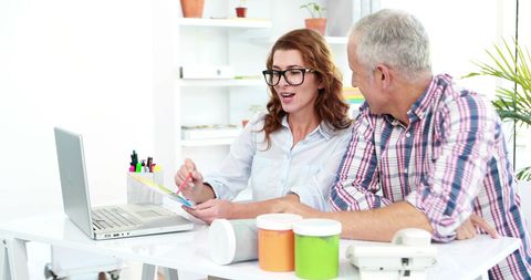Colleagues Collaborating on Laptop Project in Modern Office