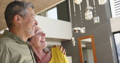 Elderly Couple Embracing in Contemporary Living Room