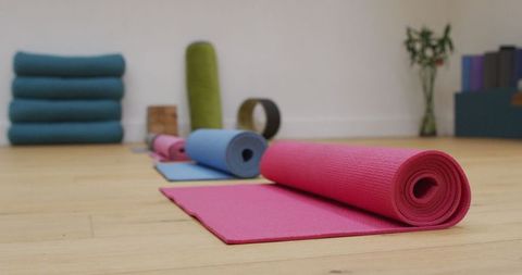 Colorful yoga mats in serene exercise studio with hardwood floor