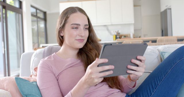 Young Woman Relaxing at Home Using Tablet for Leisure - Download Free Stock Images Pikwizard.com