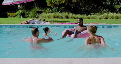 Diverse Friends Enjoying Relaxing Day in Pool