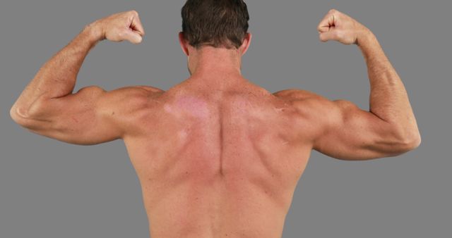 A Caucasian middle-aged man showcases his muscular back and biceps, flexing his arms upward, with copy space. His well-defined muscles emphasize a strong physique and dedication to fitness.