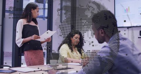 Woman presenting reports, colleagues taking notes in modern tech-enabled boardroom