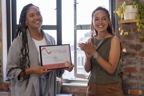 Diverse Coworkers Celebrating Certificate of Achievement in Office