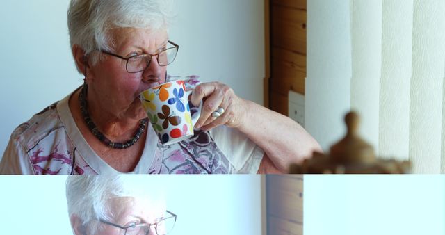 Senior Caucasian woman enjoys a cup of tea at home, with copy space. She's relaxing indoors, creating a cozy and serene atmosphere.