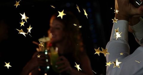 Bartender shaking cocktail and woman holding drinks with gold star celebration overlay