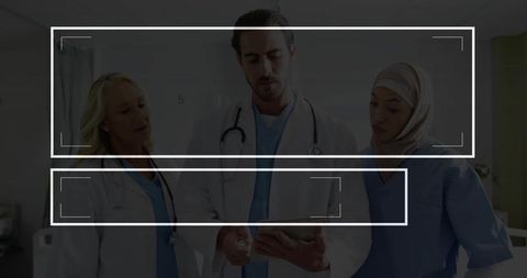 Diverse medical team discussing patient information in hospital corridor