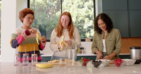 Diverse Women Preparing Fresh Smoothies in Modern Kitchen