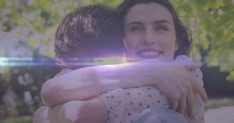 Joyful Couple Embracing Outdoors Amid Sparkling Light