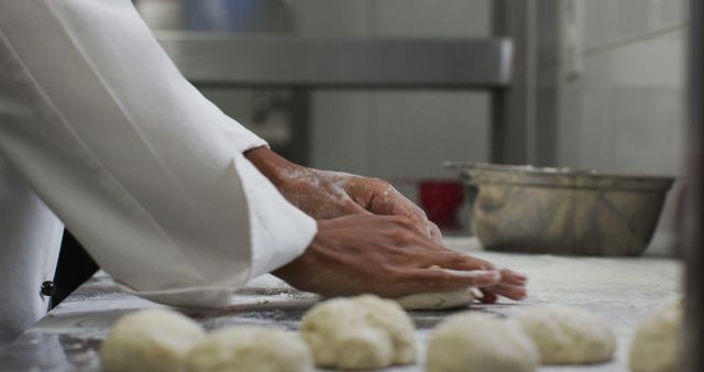 Midsection of biracial female chef preparing dough adding flour. Working in a busy restaurant kitchen.