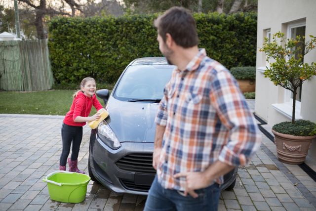 Teenage girl and father washing a car - Download Free Stock Photos Pikwizard.com
