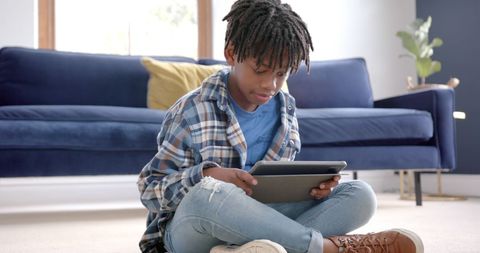 Focused Boy Engaging with Tablet on Living Room Floor