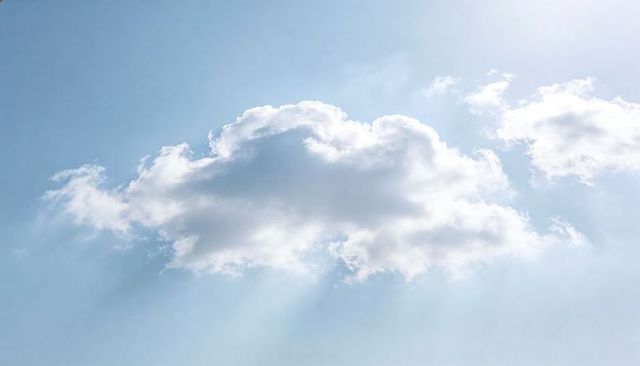 Floating Cumulus Cloud Piercing Sun Rays Across Soft Blue Sky, Airy Minimal Atmosphere