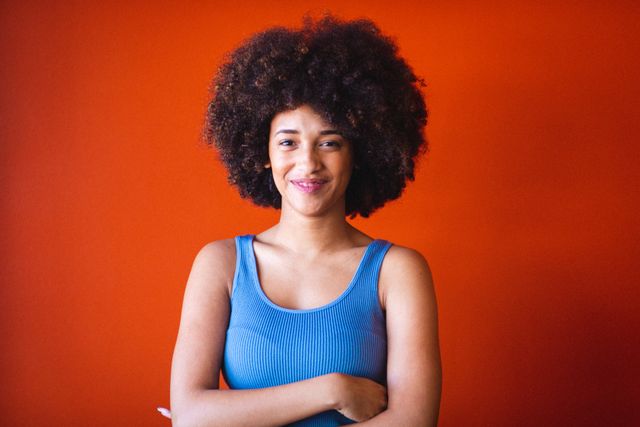 Portrait of smiling young afro african american businesswoman against orange wall, copy space. unaltered, business, corporate business, occupation and office concept.