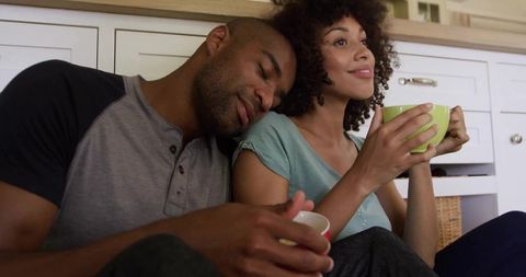 Interracial Couple Enjoying Quiet Moment in Cozy Kitchen