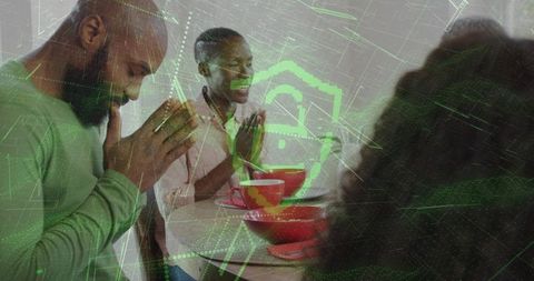 Family praying together at kitchen table with red bowls and futuristic green hud overlay