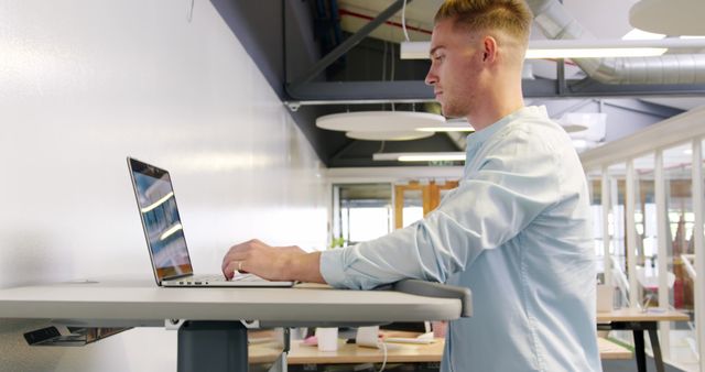 Young Professional Working at Standing Desk in Modern Office - Download Free Stock Images Pikwizard.com